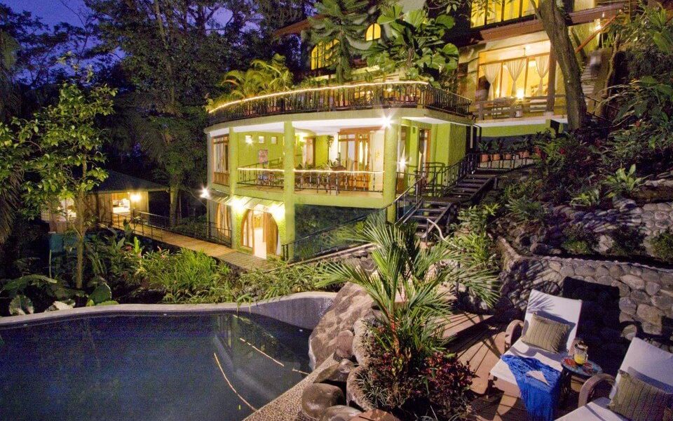 The amazing 5-story mansion villa in a night time view from the pool deck.