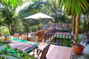 The tranquil lovely terrace at this vacation luxury rental has lots of seating and a pool view.