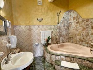 This bathroom off the game room has a whirlpool tub with a beautiful stone wall design.