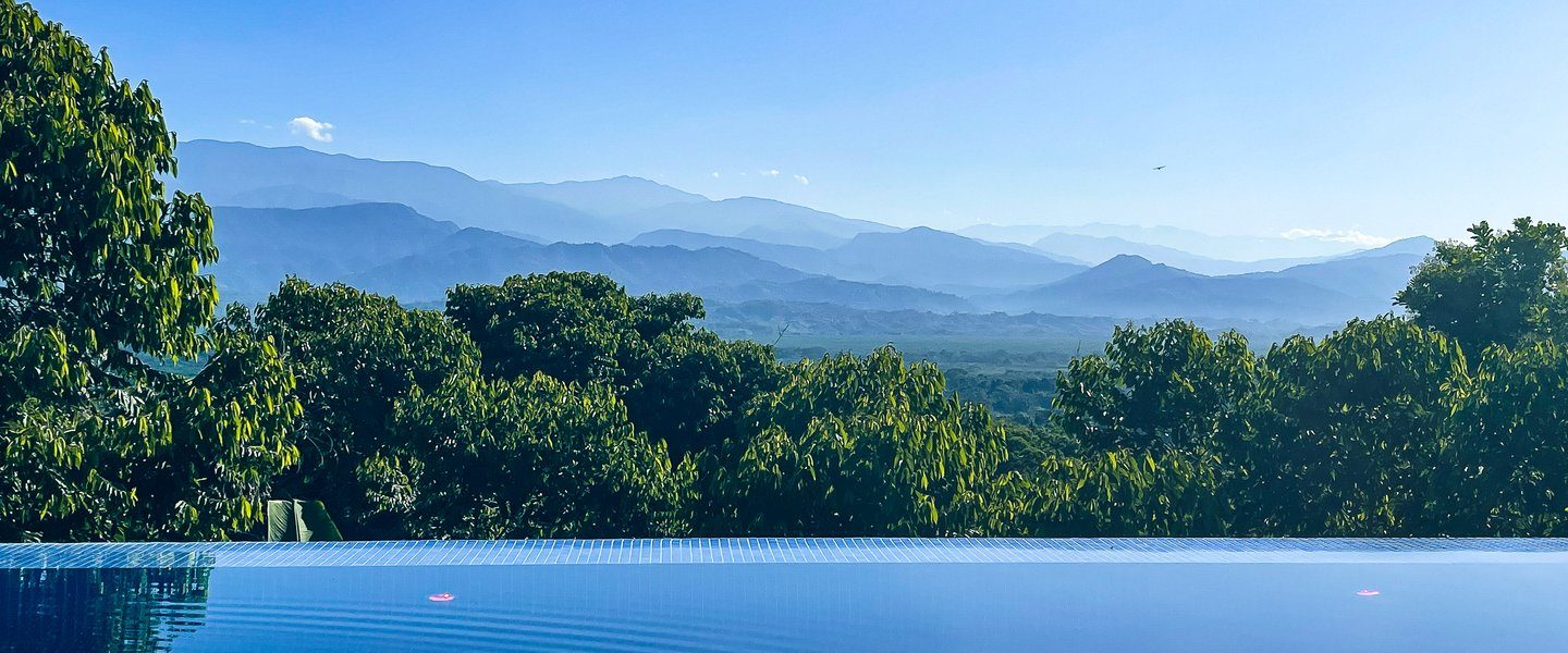 See lush green canopies and beautiful distant mountains from your private infinity pool.